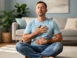 An adult seated comfortably with eyes closed, practicing calming breathing and mindfulness in a quiet living room.